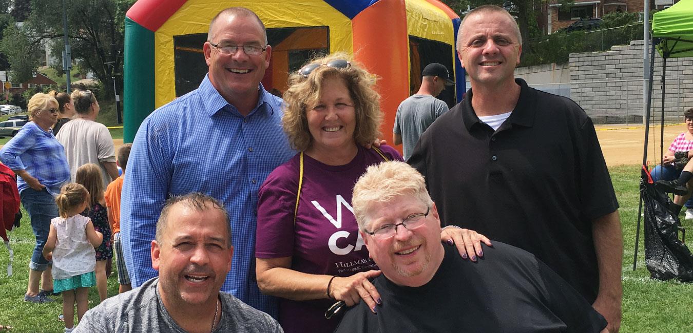 Representative Deasy posing for photot with smiling group of people at outdoor event