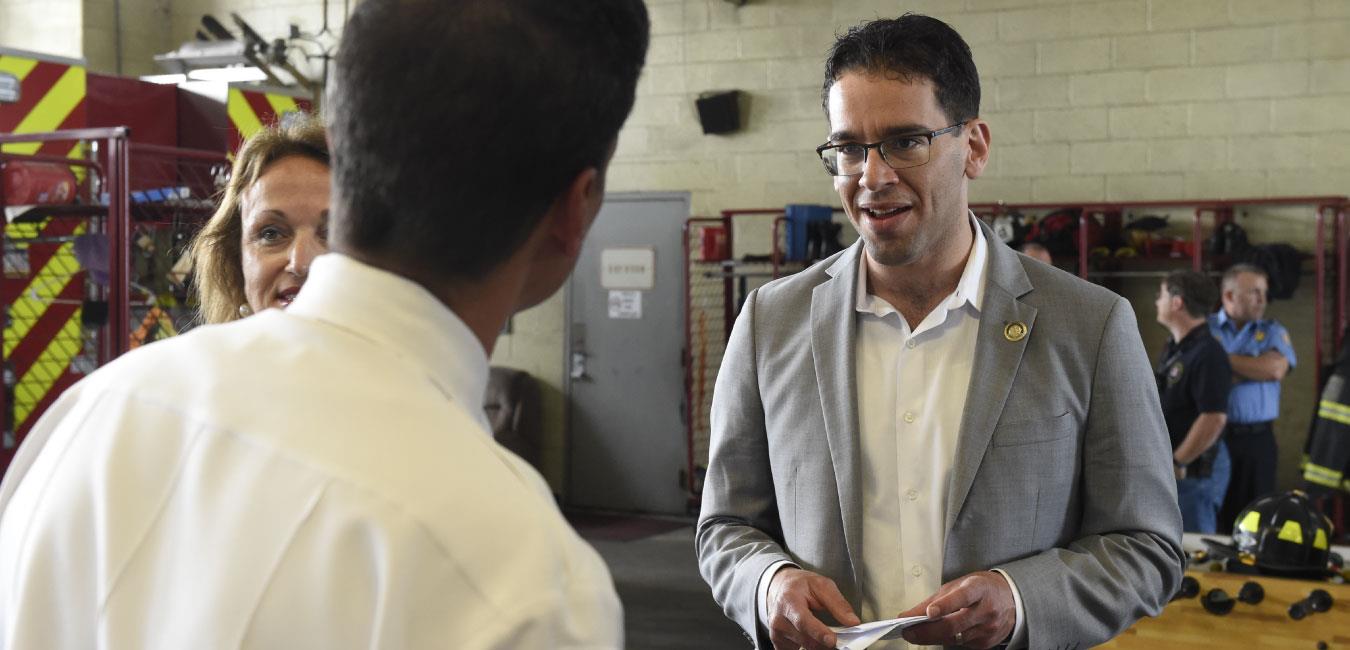 Representative Schlossberg speaking to man at firehouse