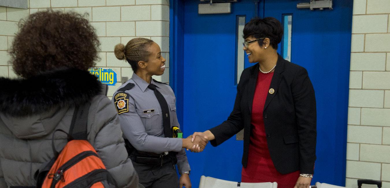 Representative Cephas shaking hands with female state police trooper