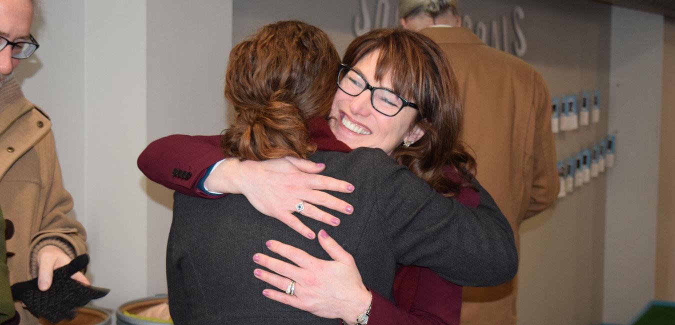 Representative Isaacson smiling and hugging woman