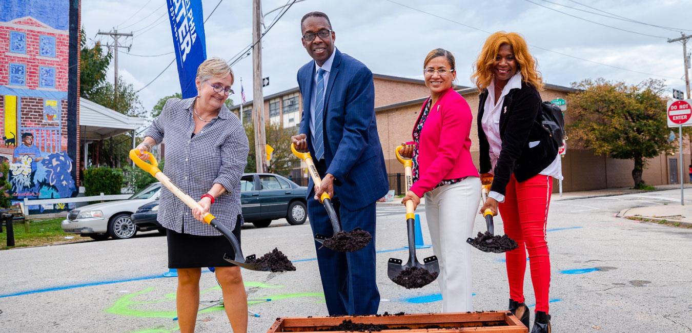 Representative Bullock shoveling dirt with local officials at ground breaking ceremony