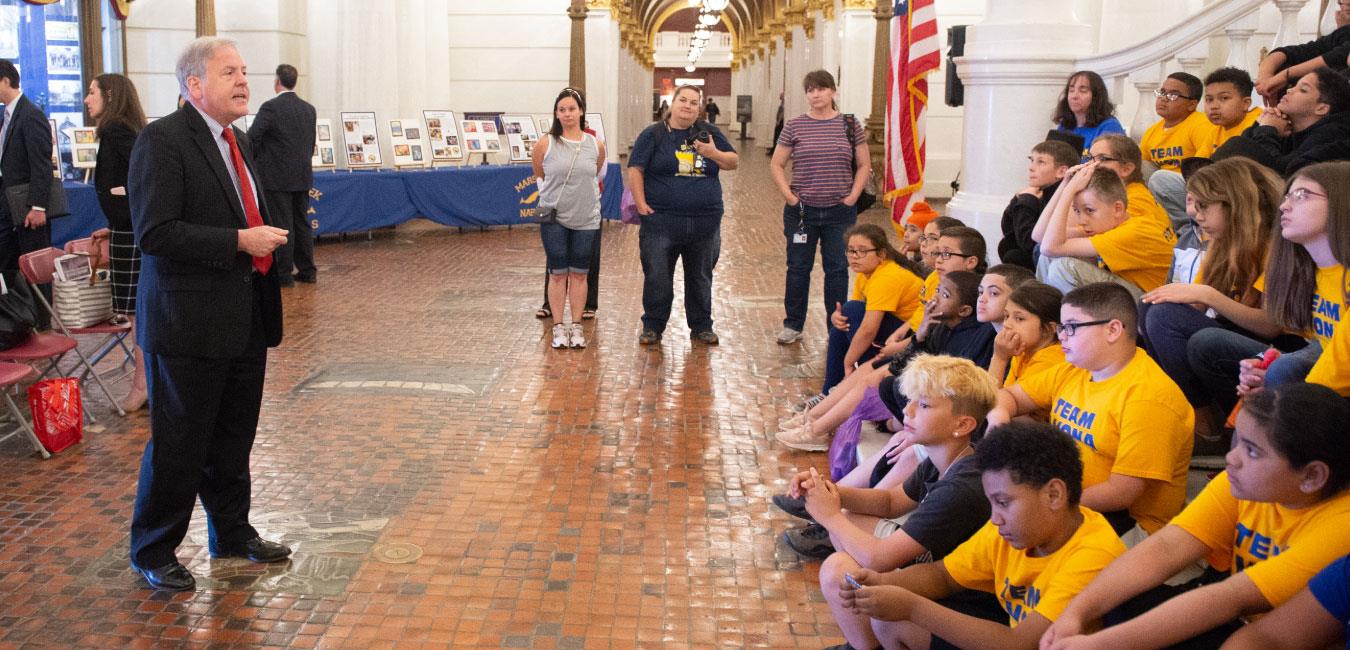 Representative Freeman addressing group of students sitting on Capitol Rotunda steps