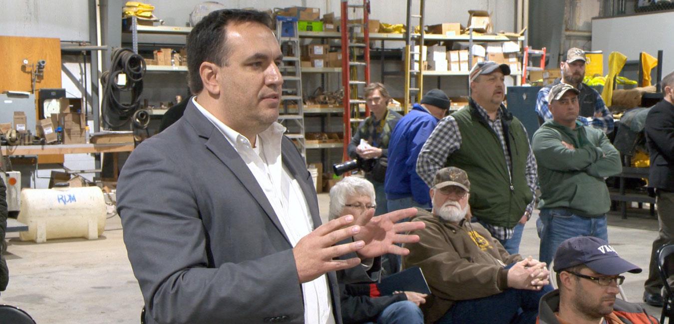 Representative Burns speaking to group of people in warehouse