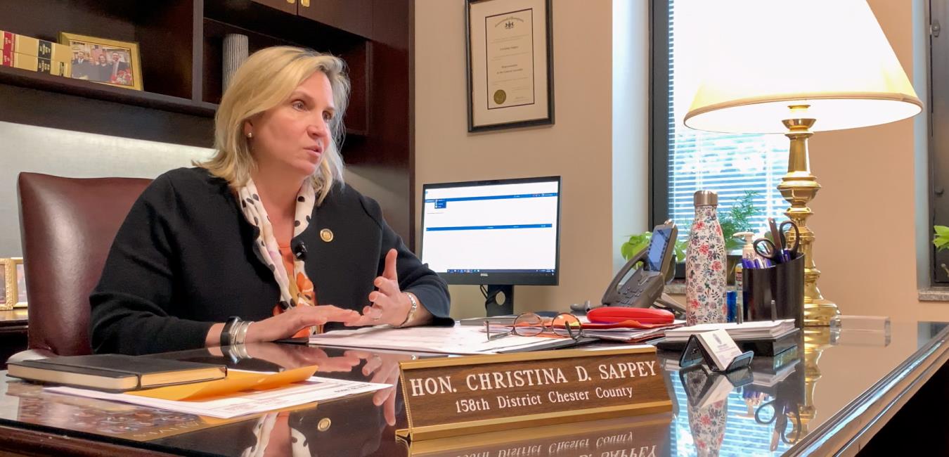 Representative Sappey speaking to someone off-camera while sitting at desk