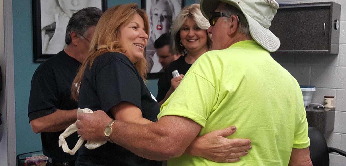 Representative Tina Davis embracing man in bucket fishing hat