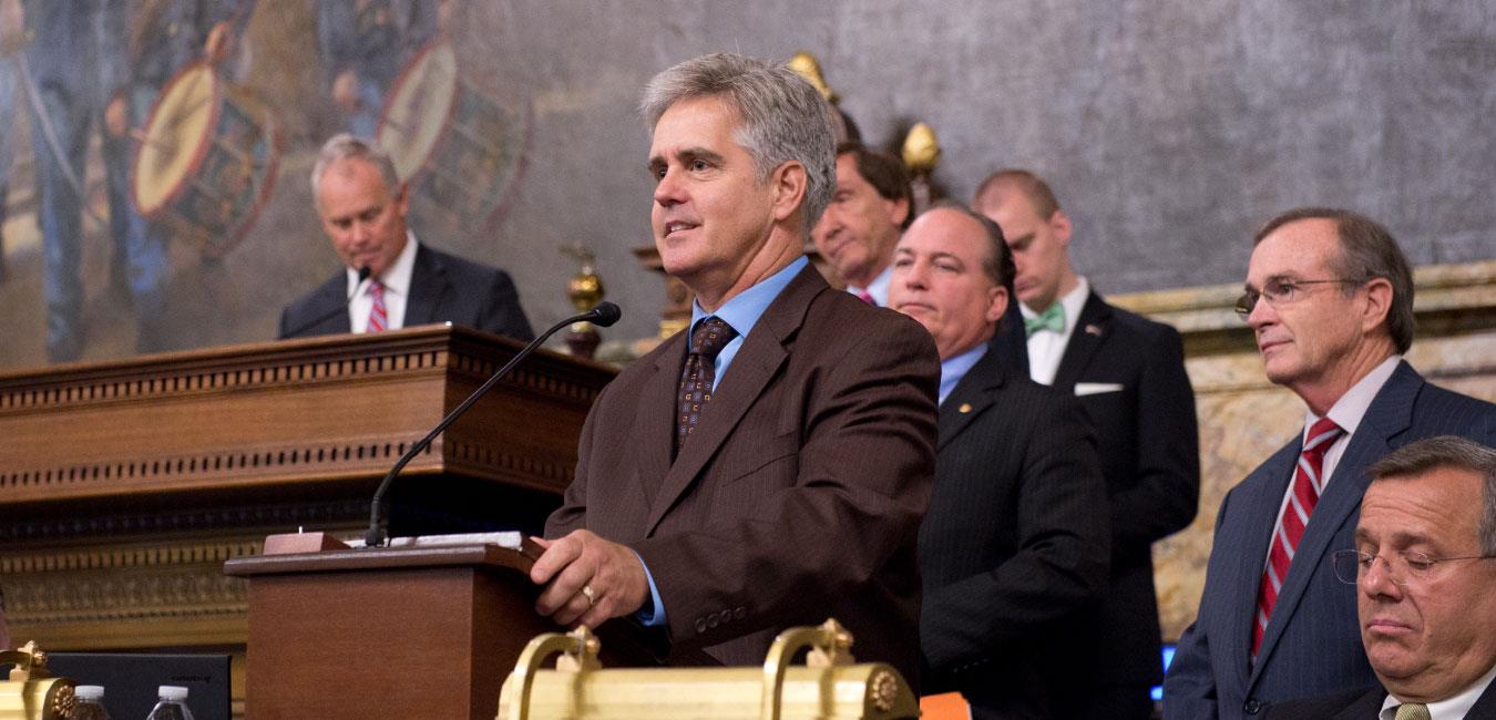 Representative Conklin standing at podium and addressing the chamber on the House floor