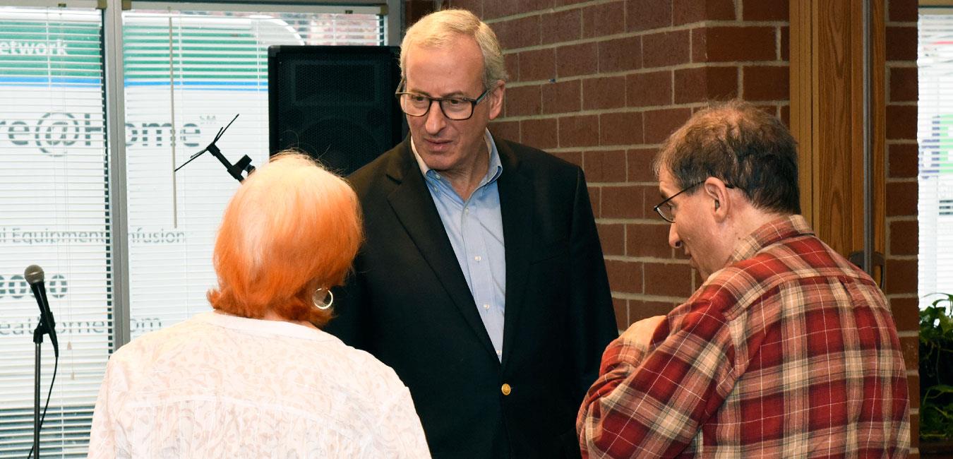 Representative Frankel speaking to two senior citizens