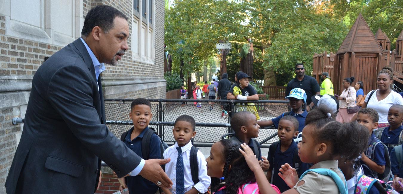 Representative Rabb speaking to group of young students at playground