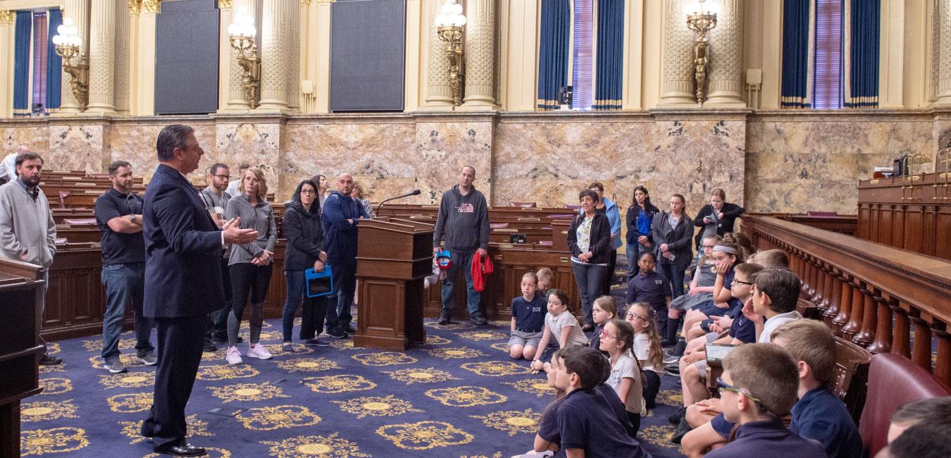 Representative Delloso addressing group of students taking tour of House floor