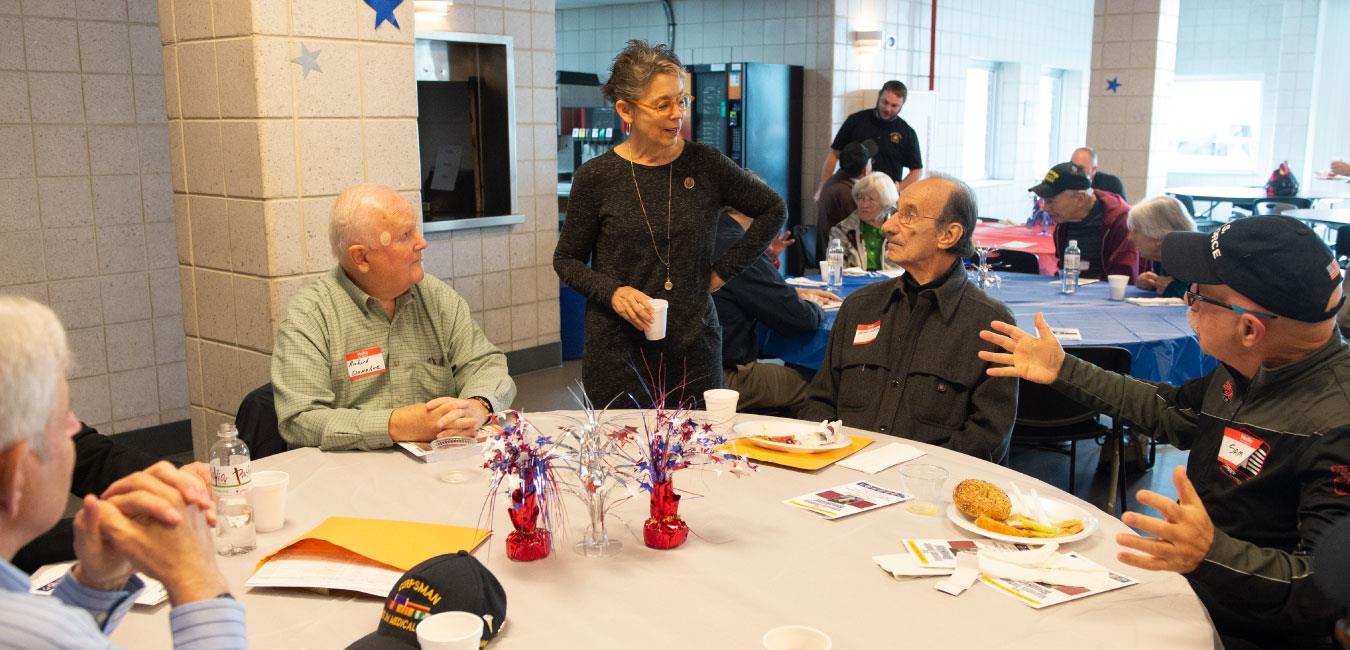 Representative Daley speaking to group of senior citizens sitting at table