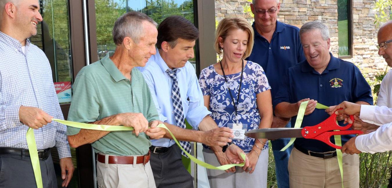 Representative Vitali holding ribbon with group at ribbon cutting ceremony