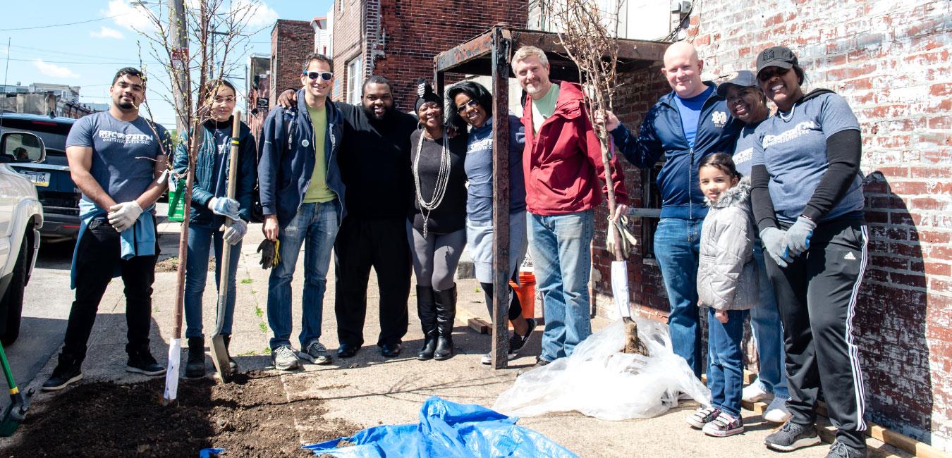 Representative Harris posing for photo with group of volunteers outside in Philadelphia